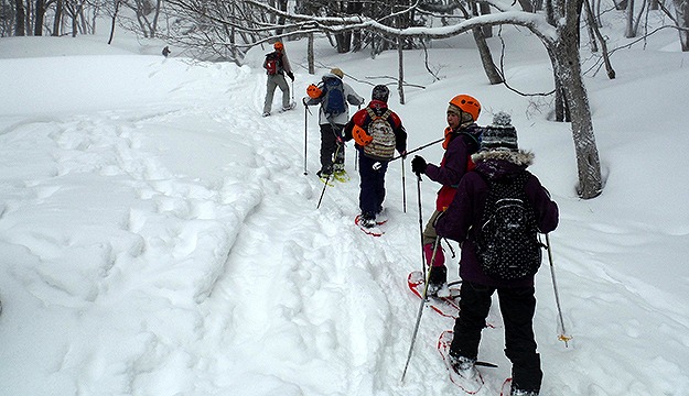 スノーシューを履きながら雪道を歩く